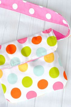 a polka dot purse is laying on the floor with it's strap open and ready to be sewn