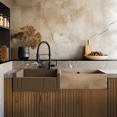 a kitchen sink sitting under a faucet next to a counter top with a vase on it