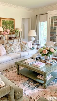 a living room filled with lots of furniture and flowers on top of a coffee table