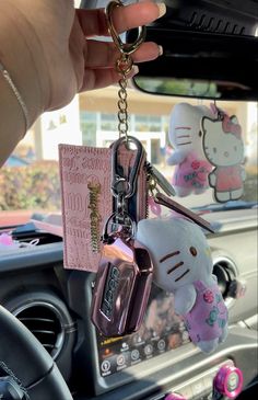 hello kitty keychain hanging from the dashboard of a car