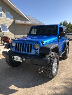 a blue jeep parked in front of a house