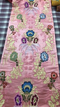 a pink table runner with colorful flowers on it