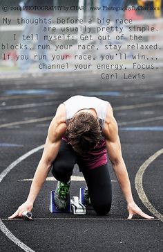 a man kneeling down on top of a track with his hands in the air while holding onto an object