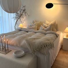 a bed with white sheets and pillows in a room