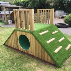 a wooden play structure with grass on top