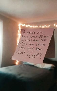 a note attached to a bed with lights in the background