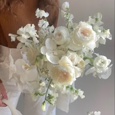 a woman holding a bouquet of white flowers