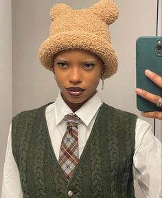 a woman wearing a teddy bear hat while taking a selfie