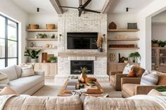 a living room filled with furniture and a flat screen tv mounted on the wall above a fire place