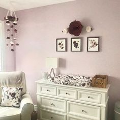 a baby's room with pink walls and white furniture