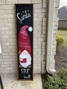 a painted sign on the side of a brick building that says santa stop and let it snow