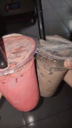 two people holding drinks in their hands with straws sticking out of the top one