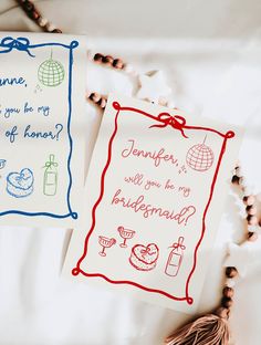 two handmade greeting cards sitting on top of a white bed next to rosarys