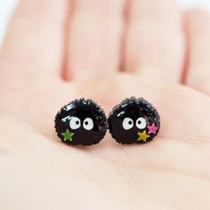 So cute!! Make your ears happy with these adorable earrings featuring cute little Studio Ghibli inspired Susuwatari (Black Soot Sprites), handcrafted by our talented artist Fancypop! These cute earrings are accented with little star sequins and are resin coated for a glossy finish. Your new favorite earrings! About These Earrings: Size: 12mm x 11mm (~0.47in x 0.473in) Materials: Resin, Glitter, Star Sequins Stainless Steel posts with butterfly backings One Pair Handmade Black Enamel Earrings, Cute Black Earrings As A Gift, Cute Black Hypoallergenic Earrings, Cute Black Earrings For Gift, Cute Handmade Enamel Earrings, Cute Black Earrings For Gifts, Cute Black Earrings For A Gift, Cute Hypoallergenic Black Earrings, Quirky Handmade Black Earrings