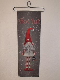 a christmas banner hanging on the wall with a gnome holding a lantern in his hand