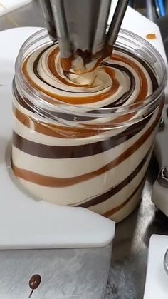 someone is making some kind of cake with chocolate and caramel swirls on it