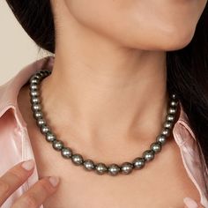 This one-of-a-kind necklace is composed of round, AA+/AAA quality Tahitian pearls measuring 8.2-10.6Â mm in diameter and approximately 18 inches in length including the clasp. The dark green strand has hints of peacock overtones, sharp luster, exhibits some natural markings, and the pearls are arranged to complement their individual beauty. Your strand will arrive double-knotted on color-matching silk. The knots protect your pearls from rubbing against each other, and if your necklace ever break Classic Tahitian Pearl Round Bead Necklaces, Classic Tahitian Pearl Round Bead Necklace, Classic Tahitian Pearl Beaded Necklace, Formal Tahitian Pearl Necklaces With Round Beads, Tahitian Pearl Round Beads Formal Necklace, Formal Tahitian Pearl Round Bead Necklaces, High Luster Tahitian Pearl Necklace, Classic Round Tahitian Pearl Necklaces, Classic Tahitian Pearl Round Necklaces