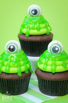 three cupcakes with green icing and googly eyes