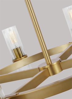 a gold chandelier with three lights on each side and two clear glass shades