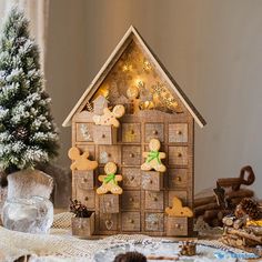 a gingerbread house on a table next to a small christmas tree and other decorations