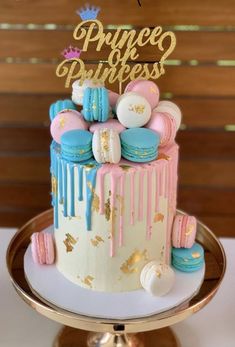 a princess cake with pink, blue and gold icing on it's top