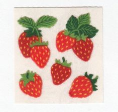 four strawberries on a white background with green leaves