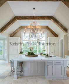 a kitchen with an island and chandelier hanging from the ceiling