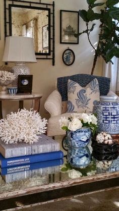 a living room filled with lots of furniture next to a wall covered in framed pictures