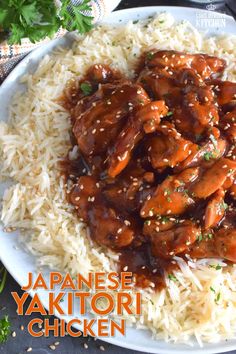 a white plate topped with rice and meat covered in sauce next to chopsticks