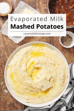 a bowl filled with mashed potatoes on top of a wooden table next to other ingredients