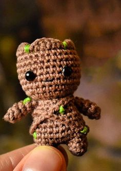 a tiny crocheted teddy bear with green eyes