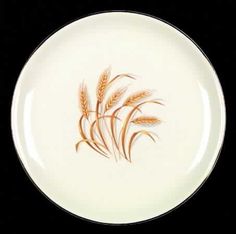 an orange and white plate with some brown designs on the side, in front of a black background