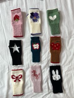 nine knitted mittens with flowers and hearts on them, all in different colors