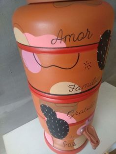 an orange vase with pink and black designs on it