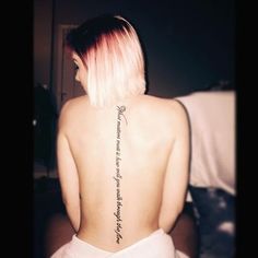 a woman with pink hair and tattoos on her back