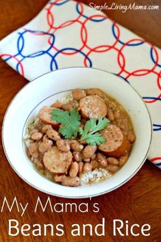 a white bowl filled with beans and rice on top of a wooden table next to a napkin