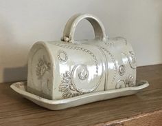 a white ceramic purse sitting on top of a wooden table