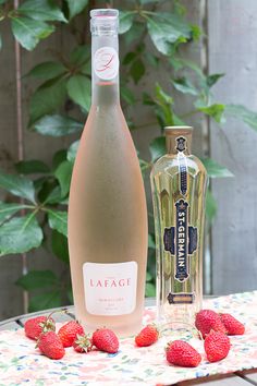 a bottle of lafage next to strawberries on a table