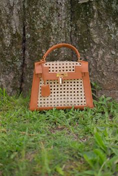 Our Maya rattan and leather trim handbag is a classic fun way to complete any look this season. Our handbags are all handmade. Want to add a little something special to your handbag? Accessorize with our 100% silk scarves. Ready to Ship! Please allow 1-2 business days to process your order and ship. Details: Rattan Leather trim Handmade Made in Indonesia Trendy Brown Top Handle Straw Bag, Brown Square Straw Bag With Detachable Handle, Designer Straw Bags For Daily Use, Designer Straw Top Handle Bag, Designer Shoulder Bag With Bamboo Handle In Natural Color, Designer Straw Bag With Bamboo Handle For Travel, Designer Rectangular Straw Bag With Detachable Handle, Designer Brown Bags For Vacation, Designer Brown Straw Bag For The Beach