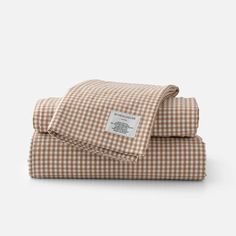 the brown and white checkered sheets are folded on top of each other, with a label