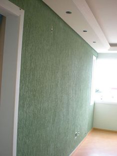 an empty room with green walls and wood floors