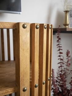 the back side of a wooden chair with metal studs on it's sides