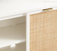 a close up of a white shelf with a rattan covering on the top and bottom