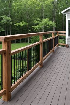 a wooden deck with black iron railings and white house in the backround