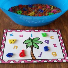 a blue bowl filled with letters and a palm tree