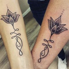 two people holding hands with tattoos on their arms and legs, one has a flower in the middle