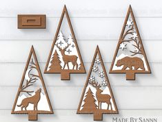 three wooden christmas trees with deer and snowflakes on them in the shape of mountains