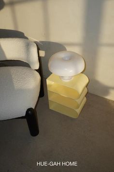 a white chair sitting next to a stack of yellow and white boxes on the floor