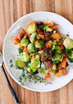 a white plate topped with brussel sprouts and sweet potatoes