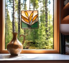 a vase sitting on top of a window sill next to a stained glass window